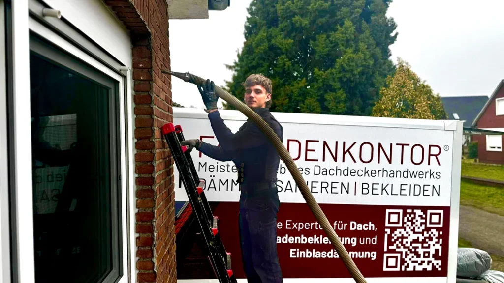Dachdeckermeister Sandro Hohnemann bei der Einblasdämmung einer Fassade in Hannover